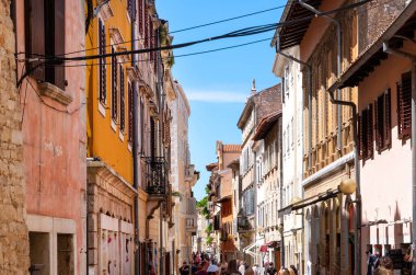 Hırvatistan 'ın Porec kentindeki eski şehir sokaklarında insanlar yürüyor