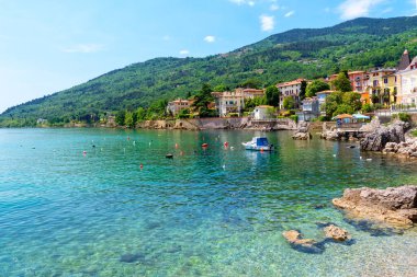 Hırvatistan 'ın Lovran kentinde tekne ve kayalarla dolu güzel bir kıyı şeridi