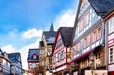 Idstein 'in şehir manzarası, mavi gökyüzünün altında sıralanmış renkli ahşap evlerle geleneksel Alman mimarisini gözler önüne seriyor.