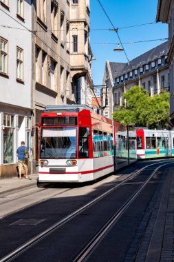 Erfurt, Thuringia 'dan canlı bir sahne. Şehrin tarihi caddelerinde modern kırmızı beyaz bir tramvay geziyor.