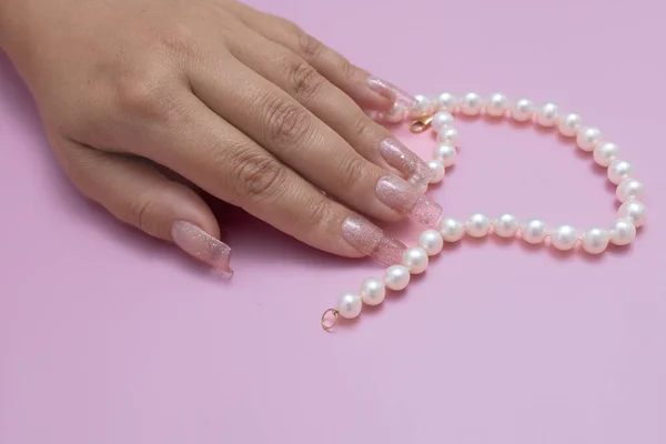 stylish women\'s manicure , beautiful women\'s hands on a pink background