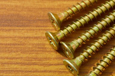 Bir grup bronz renkli vida yakın çekim, ahşap bir masada uzanmış fotoğraf