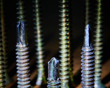 Kendine dokunan vida grubu bronz rengi yakın çekim, ahşap bir masa üzerinde fotoğraf