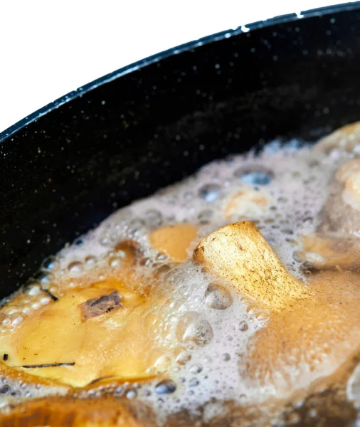 in a pot of boiling water , very tasty freshly picked mushrooms are cooked , a close - up view from above , edible gifts of the forest