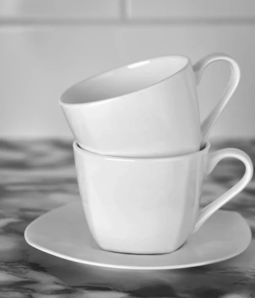黒と白の白いソーサーの上に白いコーヒーマグカップが2つ — ストック写真