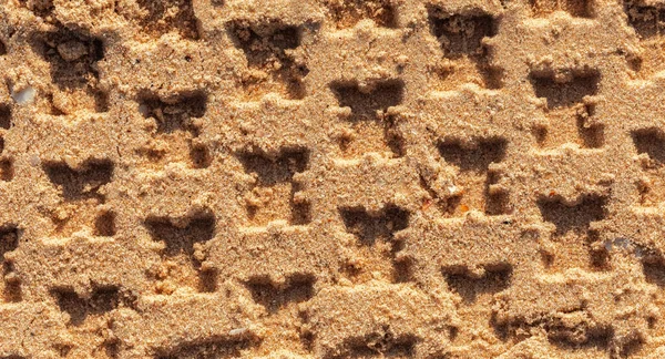 stock image The tread marks of the car in the sand. sea sand . Pattern. abstract background. The imprint of a car wheel. Textured sand. Enter the drawing.