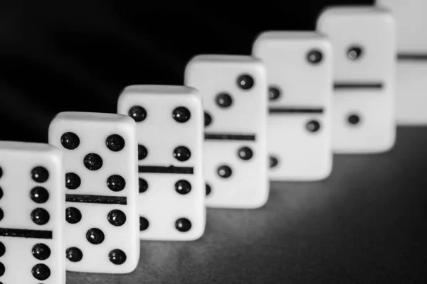 Bir grup beyaz domino taşı yakın plan, siyah beyaz fotoğraf.