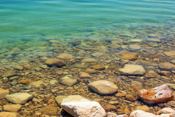 Ölü denizin sıcak ve sakin sularında büyük taşlar.