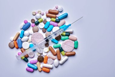 Plastik şırınga ve ilaçlar beyaz arka plan, üst görüş, tıp ve sağlık hizmetleri kavramı üzerinde fotoğraflandı