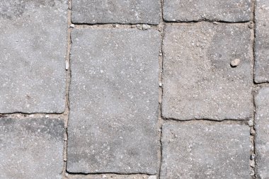 Duvarın dokusu gri, pürüzlü taş kullanılarak oluşturulur.