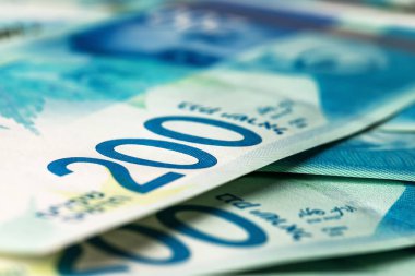 Masanın üzerinde 200 şekel banknot yığını var, yakın plan yan görüş, yeni İsrail şekelleri, zengin yaşam kavramı.