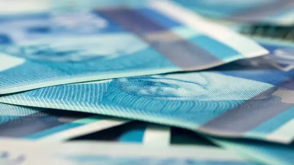 Masanın üzerinde 200 şekel banknot yığını var, yakın plan yan görüş, yeni İsrail şekelleri, zengin yaşam kavramı.