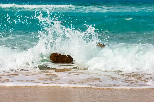 Akdeniz 'in berrak mavi suları, yumuşak deniz dalgalarının nazikçe kumlu bir kumsalda süzülüşü ile altın kumlar arasında güzel bir tezat oluşturuyor.