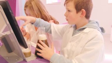 Okul çocukları deney tüpleri kullanarak modern tıp ve bilim eğitim merkezinin genetik laboratuvarını kullanıyorlar. Yüksek kalite 4k görüntü