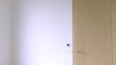 Neşeli bir kadın elinde karton bir kutuyla yeni bir eve taşınmayı simgeleyen parlak bir odaya girer. Yüksek kalite 4K görüntü.