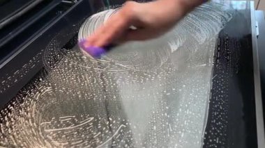 Mutfak fırınının cam camlarını temizliyorum..