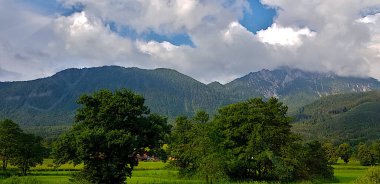 Arkasında bulutlu bir gökyüzü olan bir dağ sırası.