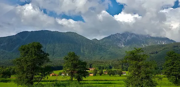 Arkasında bulutlu bir gökyüzü olan bir dağ sırası.