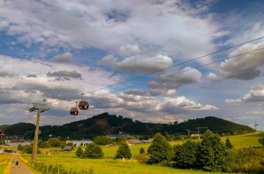 Gündüz vakti dağın tepesindeki teleferiğin dikey görüntüsü.
