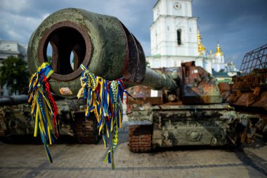 Ukrayna, Kyiv 'de halka açık bir yerde imha edilmiş bir Rus tankının ön görüntüsü. Sembolik mesajlar ve Ukrayna kurdeleleriyle kaplı paslı araç bir savaş ganimeti ve dayanıklılığın hatırlatıcısı olarak duruyor..
