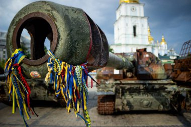 Ukrayna, Kyiv 'de halka açık bir yerde imha edilmiş bir Rus tankının ön görüntüsü. Sembolik mesajlar ve Ukrayna kurdeleleriyle kaplı paslı araç bir savaş ganimeti ve dayanıklılığın hatırlatıcısı olarak duruyor..