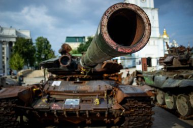 Ukrayna, Kyiv 'de halka açık bir yerde imha edilmiş bir Rus tankının ön görüntüsü. Sembolik mesajlar ve Ukrayna kurdeleleriyle kaplı paslı araç bir savaş ganimeti ve dayanıklılığın hatırlatıcısı olarak duruyor..