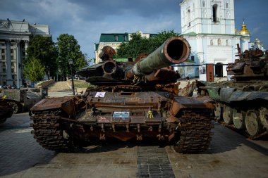 Ukrayna, Kyiv 'de halka açık bir yerde imha edilmiş bir Rus tankının ön görüntüsü. Sembolik mesajlar ve Ukrayna kurdeleleriyle kaplı paslı araç bir savaş ganimeti ve dayanıklılığın hatırlatıcısı olarak duruyor..