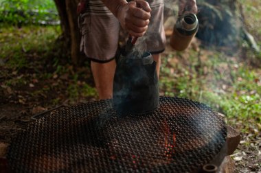 Kamp ateşinin üzerinde ısınan su. Dışarıdaki odun ateşinin üzerinde çelik bir sürahi kaynar su..
