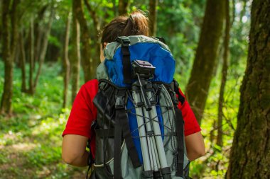 Mavi sırt çantalı ve siyah şapkalı bir kız..