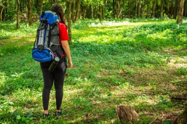 Mavi sırt çantalı ve siyah şapkalı bir kız..