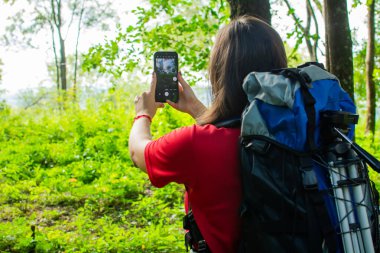 Mavi sırt çantalı ve siyah şapkalı bir kız..