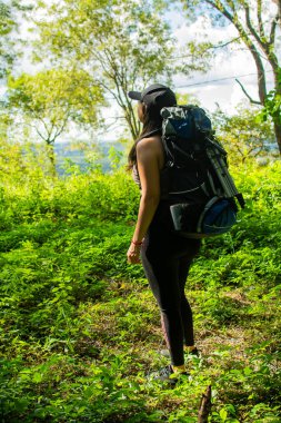 Mavi sırt çantalı ve siyah şapkalı bir kız..