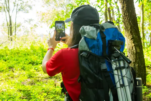 Mavi sırt çantalı ve siyah şapkalı bir kız..