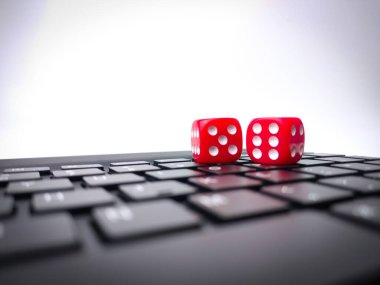 Red dice on keyboard.Playing dice for game online on computer keyboard