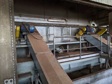 Malaysia, 25 May 2022: A blue palm kernel intake conveyor motor located in a palm kernel processing plant.