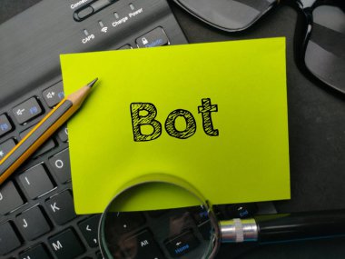 Magnifying glass and pencil with the word BOT on black background.
