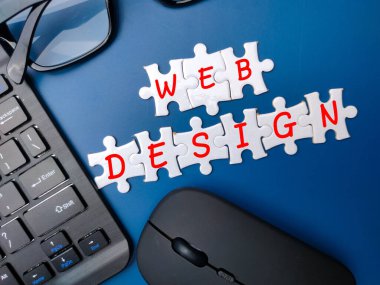 Mavi arkaplanda WEB DESIGN sözcüğüyle kablosuz klavye ve fare.