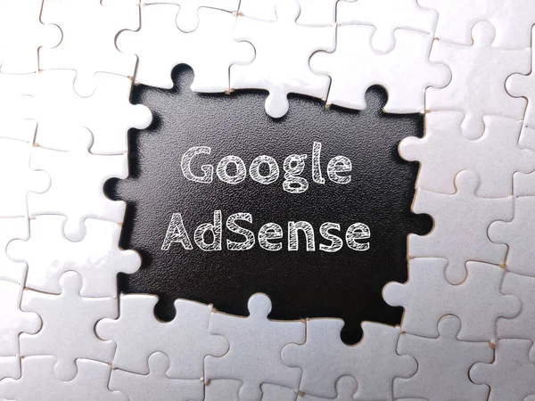 White puzzle with the word Google Adsense on black background