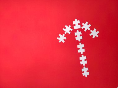 White puzzles arranged according to the shape of arrows on a red background.