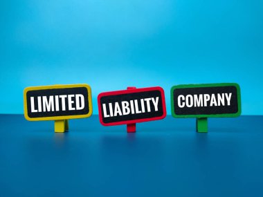 Colored wooden board with the word LIMITED LIABILITY COMPANY on blue background. Business concept.