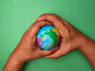 Hand holding earth globe on a green background.Nature and earth concept.