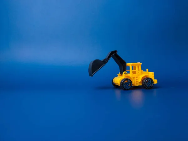Excavator model isolated on blue background with copy space.