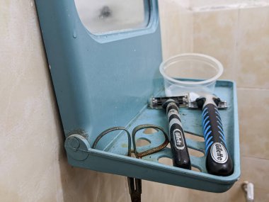 Perak, Malezya, 13 Haziran 2022: Gillette marka tıraş makinesi, sabun ve küçük bir makasla banyodaki küçük bir aynaya yerleştirildi..