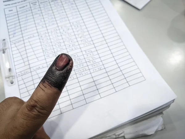 Index finger with indelible ink stain after voting in election