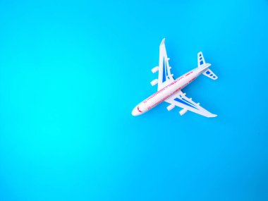 Üst görünüm beyaz oyuncak uçak mavi arkaplan üzerinde kopya alanı ile.
