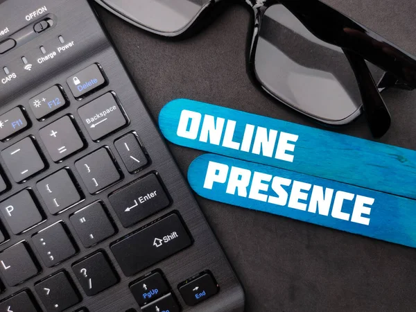 Wireless keyboard and glasses with the word ONLINE PRESENCE. Business concept.