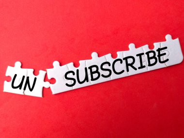 Kırmızı arkaplanda UNSUBSCRIBE yazan beyaz yapboz.