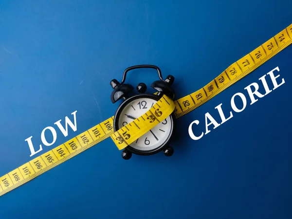 Pomiar Taśmy Budzika Słowem Low Calorie Niebieskim Tle — Zdjęcie stockowe