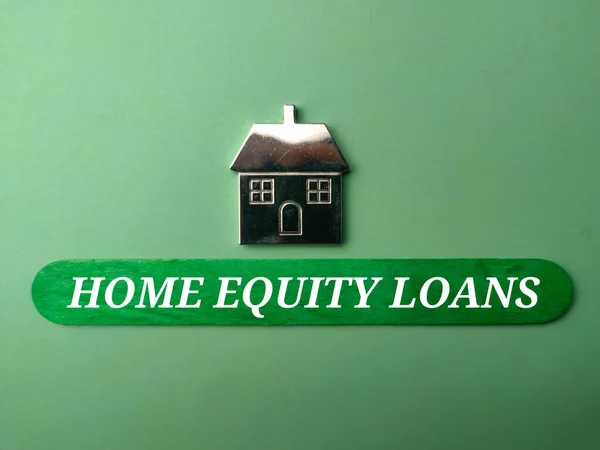 stock image Toy house with text HOME EQUITY LOANS on green background.