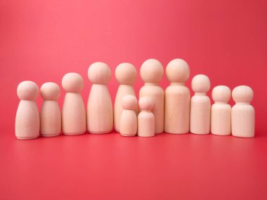 Kırmızı arka planda tahta figürler. Aile kavramı.